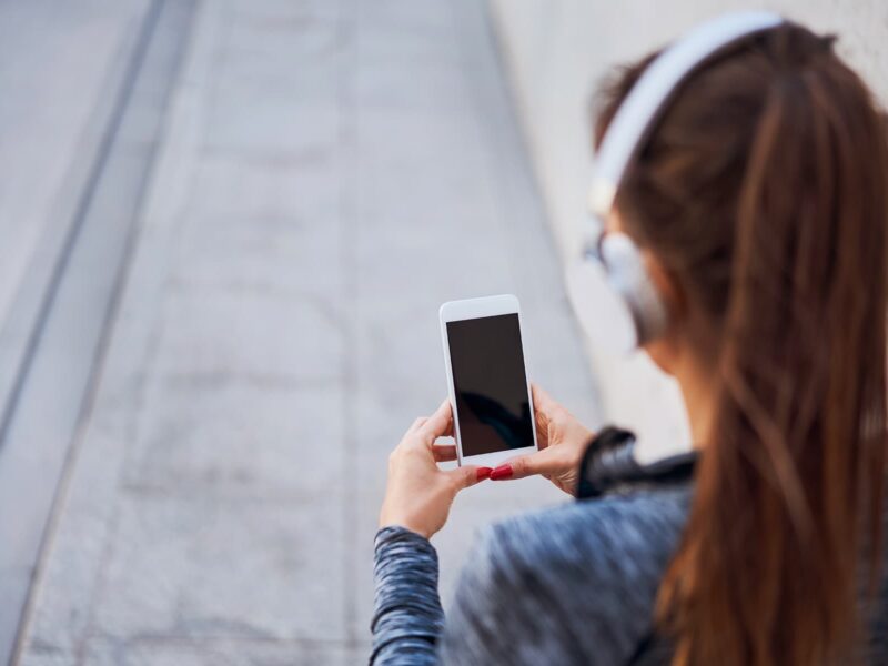 1800x1200 getty rf woman with headphones using smartphone
